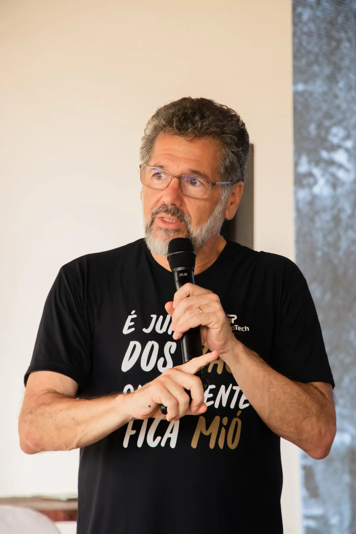 Palestrante ao microfone no palco da primeira edição
